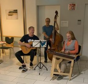 3 Musiker mit Gitarre, Kontrabass und Zitter.